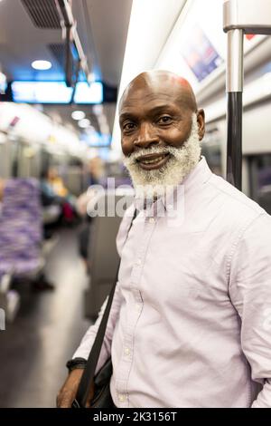 Smiling senior businessman traveling in train Stock Photo