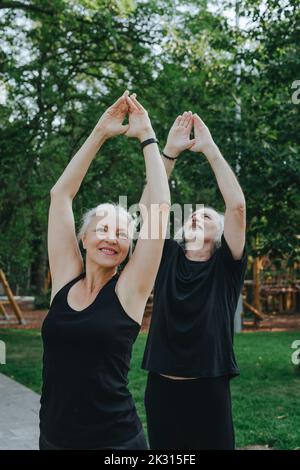 Happy couple doing stretching exercise together in park Stock Photo