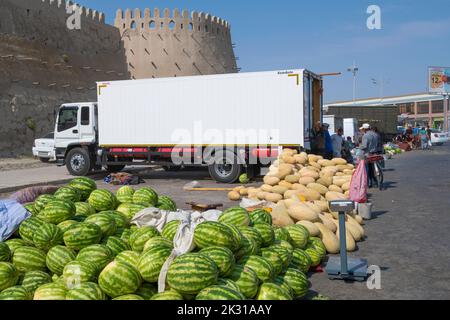 BUKHARA, UZBEKISTAN - SEPTEMBER 09, 2022: Sale of watermelons and melons at the ancient city walls. Street market. Stock Photo