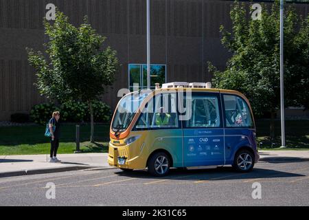 White Bear Lake, Minnesota. August 9, 2022. A woman waits to ride on the self-driving low speed multi-passenger electric shuttle. Bear Tracks.is a rese Stock Photo