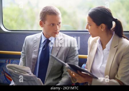 Trading during transit. young business people commuting to work. Stock Photo