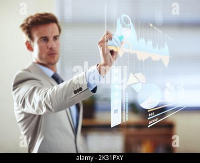 Predicting the future of modern business. a handsome young businessman using a digital interface. Stock Photo