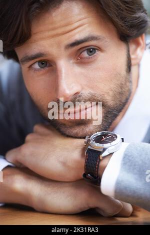 Its about time for more coffee. A cropped shot of a handsome businessman leaning on a table. Stock Photo