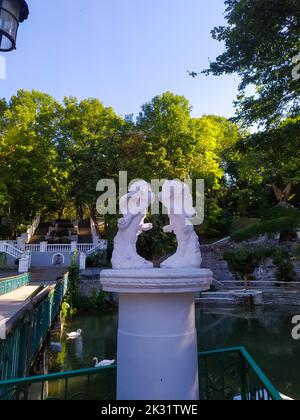 Profiles of kissing cherubs in park in Kamianets-Podilskyi Ukraine. Sculpture in the park with white kissing angels. Statue with cupid kiss. Stock Photo