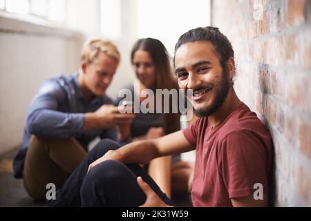 Looking forward to the next class. three students relaxing in the hallway. Stock Photo
