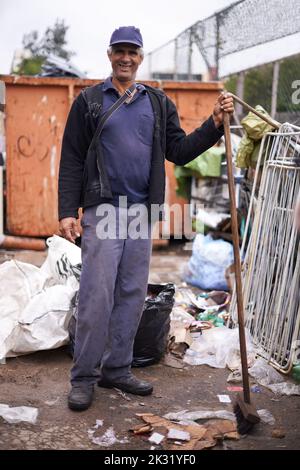 Keeping our city clean-ish. a street cleaner sweeping up garbage. Stock Photo