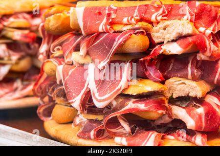 traditional Spanish bocadillos with Iberico jamon laid out in a slide on a shop window Stock Photo