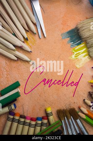 Overhead shot of school supplies with Cancelled text. Brushes, pencils, artistic tools. Art And Craft Work Tools. Stock Photo