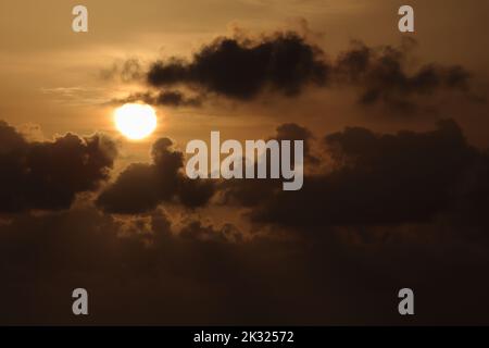 contrasting morning sky with dark clouds in front of the rising sun Stock Photo