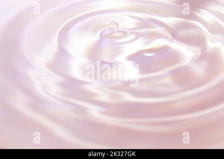 Beautiful pink-violet background in the form of circles on the water and a small drop of water. Universal abstract background. Stock Photo