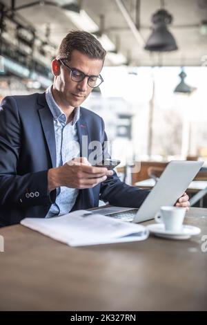 A businessman in a restaurant having coffee and taking care of his business. Stock Photo