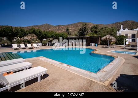 Ios, Greece - September 13, 2022 : View of a swimming pool with sun beds, sun umbrellas and a pool bar in Ios Greece Stock Photo
