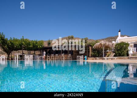 Ios, Greece - September 13, 2022 : View of a swimming pool with sun beds, sun umbrellas and a pool bar in Ios Greece Stock Photo
