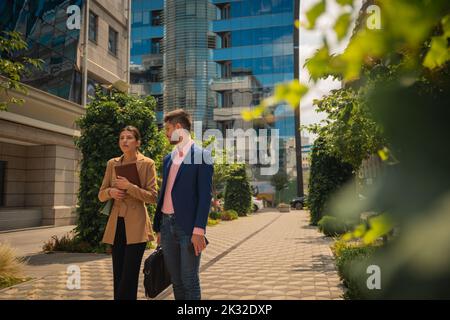 A good looking businessman and gorgeous businesswoman are going home tired after hard working on their project all day Stock Photo