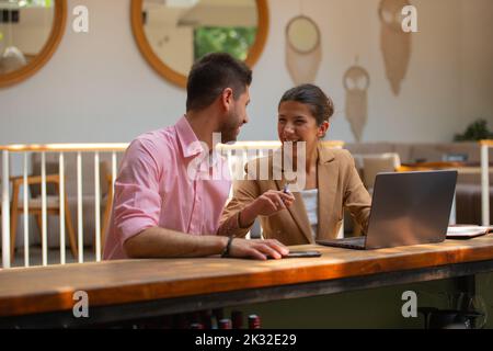 Young business couple are telling jokes and laughing while they are talking about their business project Stock Photo