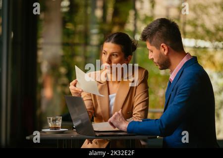 A businesswoman is holding a piece of paper in her hands while she is thinking what went wrong with her work Stock Photo