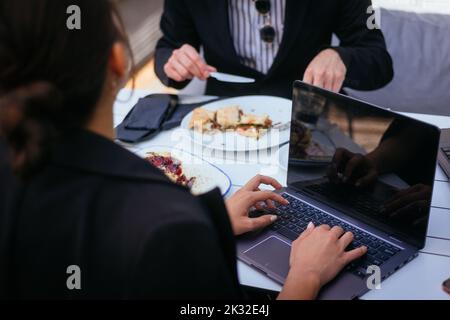 A young businesswoman is asking questions to her male partner while he is taking his breakfast Stock Photo