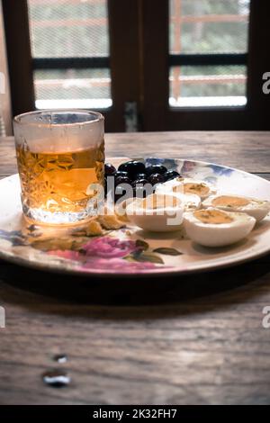 Vintage Whiskey Glass served with boiled eggs and black grapes. Uttarakhand India. Stock Photo