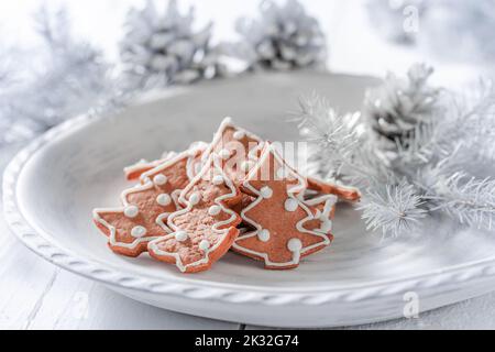 Brown and sweet Christmas gingerbread cookies on white plate. Homemade baking for Christmas Stock Photo