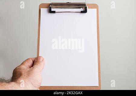 notepad with copy space in the hands of caucasian man, gray-green background Stock Photo