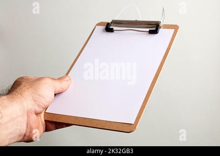 notepad with copy space in the hands of caucasian man, gray-green background Stock Photo