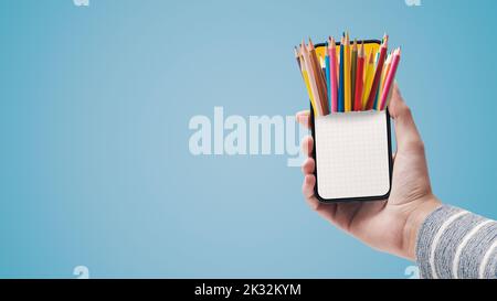 Colored pencils on smartphone, back to school and creativity concept Stock Photo
