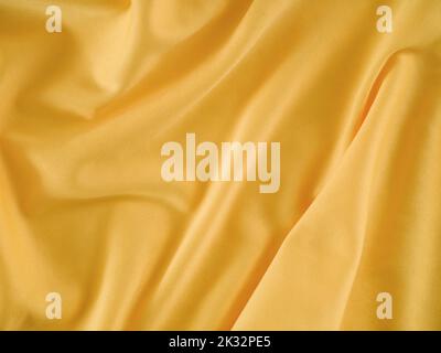 A crumpled gold fabric background. Close up. Stock Photo