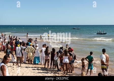 A group of people watching fishermen in canoes near the sea at Boca do Rio beach Stock Photo