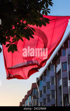 Big Turkish flag waving with crescent and star hanging on the street. Stock Photo