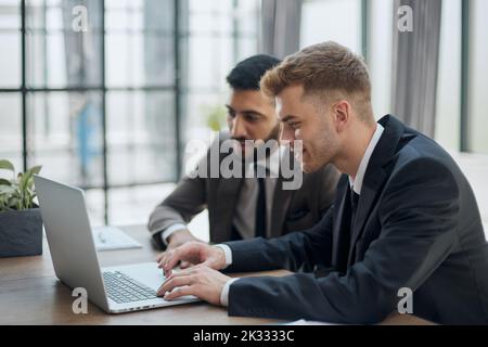 two professional businessmen discussing and using desktop computer in office Stock Photo