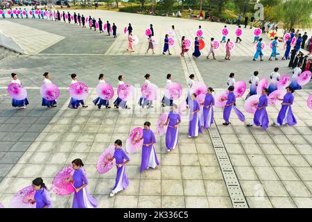 GUILIN, CHINA - SEPTEMBER 24, 2022 - Cheongsam lovers walk on the runway in front of ancient buildings in Guilin, South China's Guangxi Zhuang autonom Stock Photo