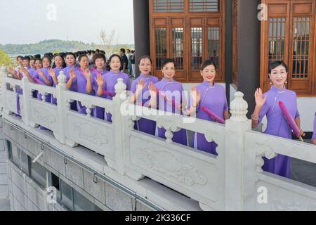 GUILIN, CHINA - SEPTEMBER 24, 2022 - Cheongsam lovers walk on the runway in front of ancient buildings in Guilin, South China's Guangxi Zhuang autonom Stock Photo