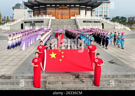 GUILIN, CHINA - SEPTEMBER 24, 2022 - Cheongsam lovers walk on the runway in front of ancient buildings in Guilin, South China's Guangxi Zhuang autonom Stock Photo