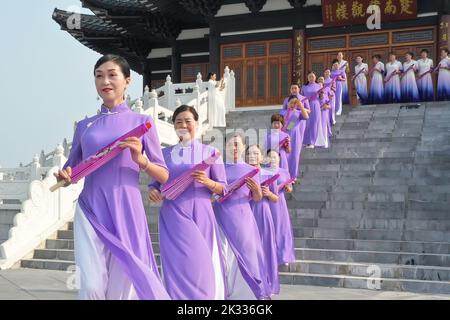 GUILIN, CHINA - SEPTEMBER 24, 2022 - Cheongsam lovers walk on the runway in front of ancient buildings in Guilin, South China's Guangxi Zhuang autonom Stock Photo