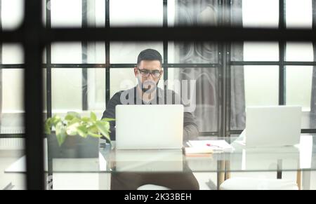 Businessman using his laptop, pc. Serious handsome bearded man worker laptop Stock Photo