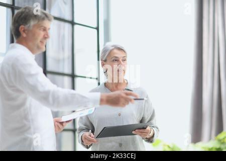 Businessman and woman working on computer together Stock Photo