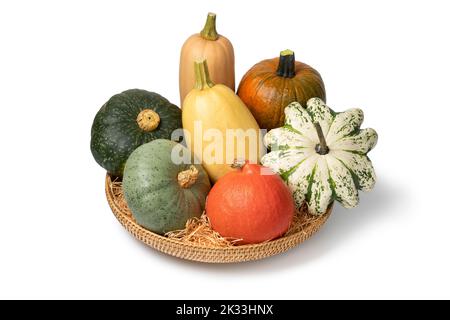 Basket with a variation of autumn pumpkins isolated on white background Stock Photo