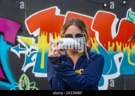 Birmingham, UK. 24th Sep, 2022. 'OK', one of about a dozen women street graffiti artists working on walls in Digbeth as part of the High Vis Street Art Festival at the Tea Works. Street art of this kind is often seen as a male dominated culture, but this is changing. Credit: Peter Lopeman/Alamy Live News Stock Photo