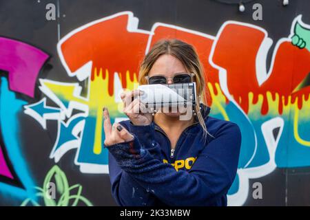Birmingham, UK. 24th Sep, 2022. 'OK', one of about a dozen women street graffiti artists working on walls in Digbeth as part of the High Vis Street Art Festival at the Tea Works. Street art of this kind is often seen as a male dominated culture, but this is changing. Credit: Peter Lopeman/Alamy Live News Stock Photo