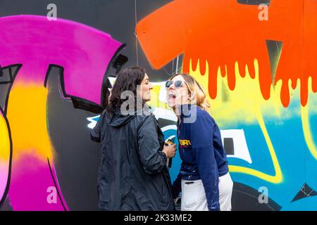 Birmingham, UK. 24th Sep, 2022. 'Zest' and 'OK' share a wall as two of about a dozen women street graffiti artists working on walls in Digbeth as part of the High Vis Street Art Festival at the Tea Works. Street art of this kind is often seen as a male dominated culture, but this is changing. Credit: Peter Lopeman/Alamy Live News Stock Photo