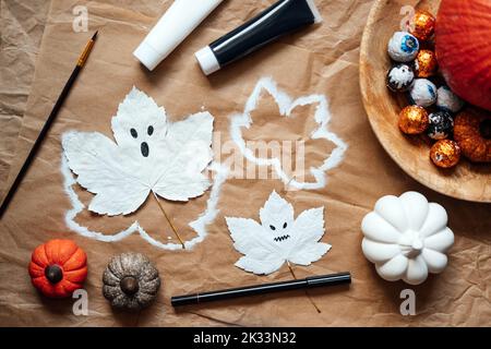 Halloween ghosts from dry maple leaves. Halloween natural DIY decor. Kids art project. Sustainable Eco-Friendly Halloween holiday decoration Stock Photo