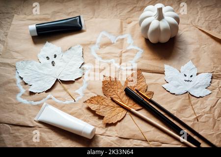 Halloween ghosts from dry maple leaves. Halloween natural DIY decor. Kids art project. Sustainable Eco-Friendly Halloween holiday decoration Stock Photo