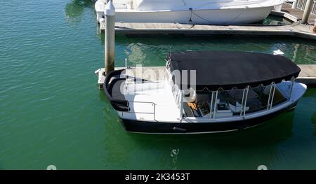 electric rental boat docked in the bay Stock Photo