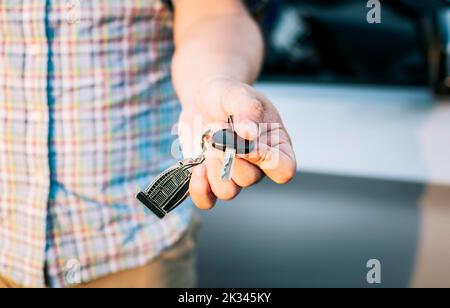Driver's hands showing the car keys, Close-up of male driver hands showing the keys, Vehicle rental concept. Close-up of people holding car keys Stock Photo