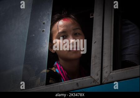 Portrait of a young Nepalese woman looking out of a window. Stock Photo