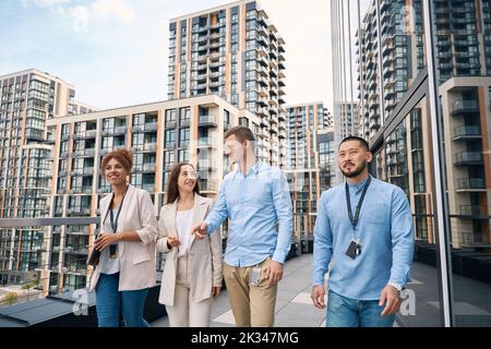 Group of entrepreneurs communicating during outdoor lunchtime walk Stock Photo