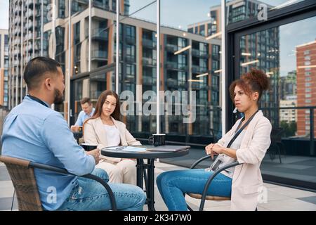 Group of businesspeople communicating during coffee break Stock Photo