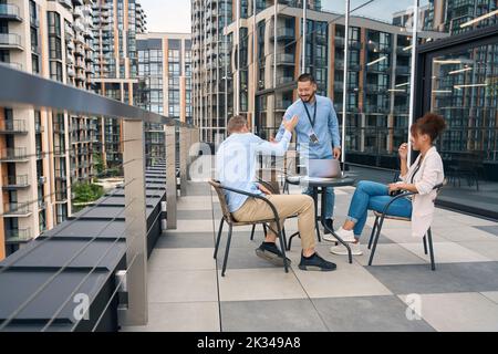 Corporate workers holding business meeting on office balcony Stock Photo