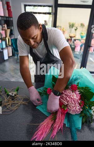 Young guy collects a bouquet of flowers Stock Photo