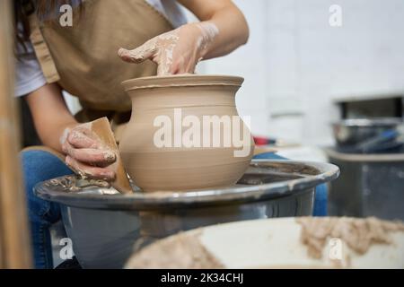 Woman potter forms earthenware on a potter wheel Stock Photo